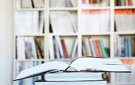 Open books and shelves of books in a bright reading space